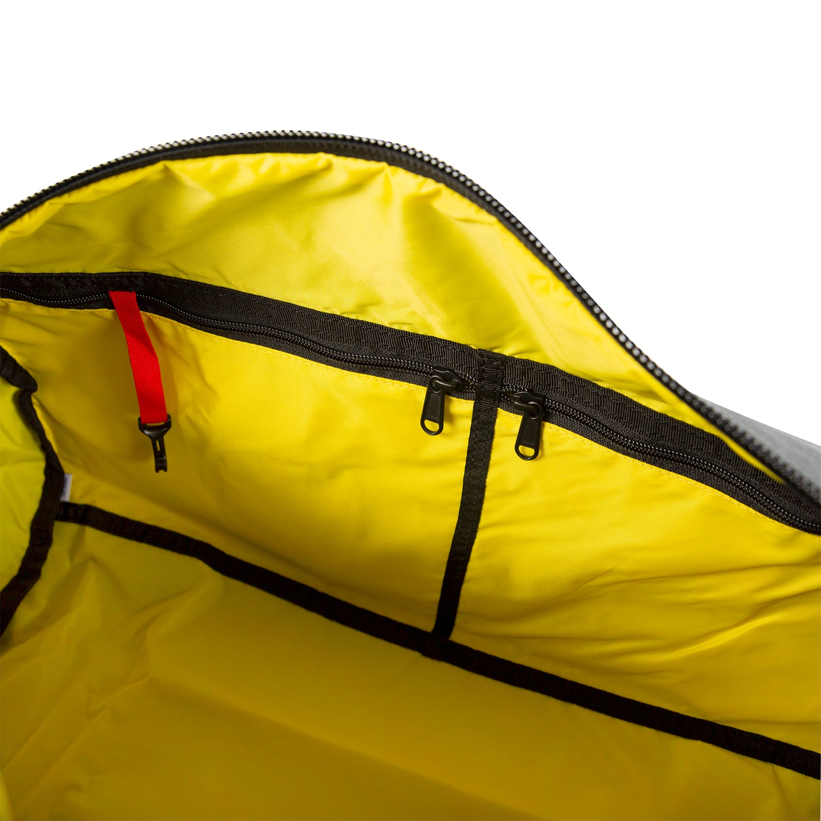General shot of interior of Topo Designs Classic Duffel 20" retro gym bag showing yellow lining, zipper pockets, and red key clip.