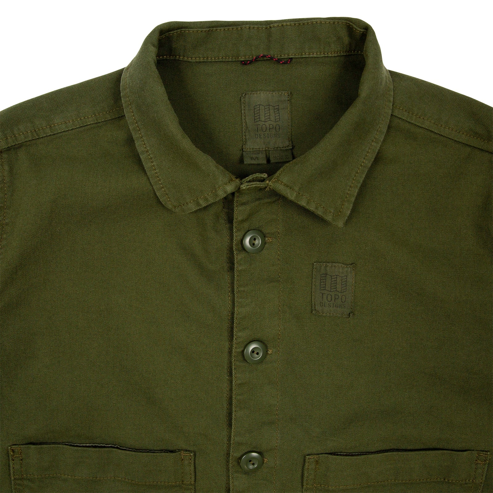 General detail shot of Topo Designs Women's Dirt Jacket in Olive green showing collar, inside tag, chest logo, and buttons.