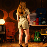 General lookbook image of Topo Designs Dirt Romper on model in studio setting shown in "Oil Green" [Model is 5'10", wearing size medium]