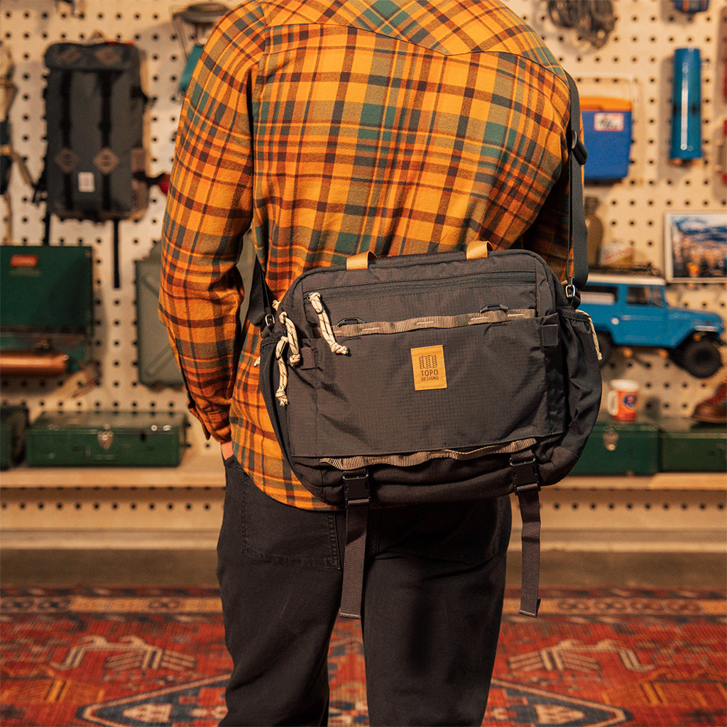 General on model shot of Mountain Cross Bag in "Black / Neutral" worn crossbody on back