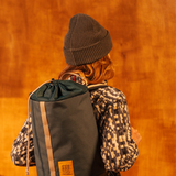 General image of person wearing a charcoal waffle knit beanie standing against a white wall.