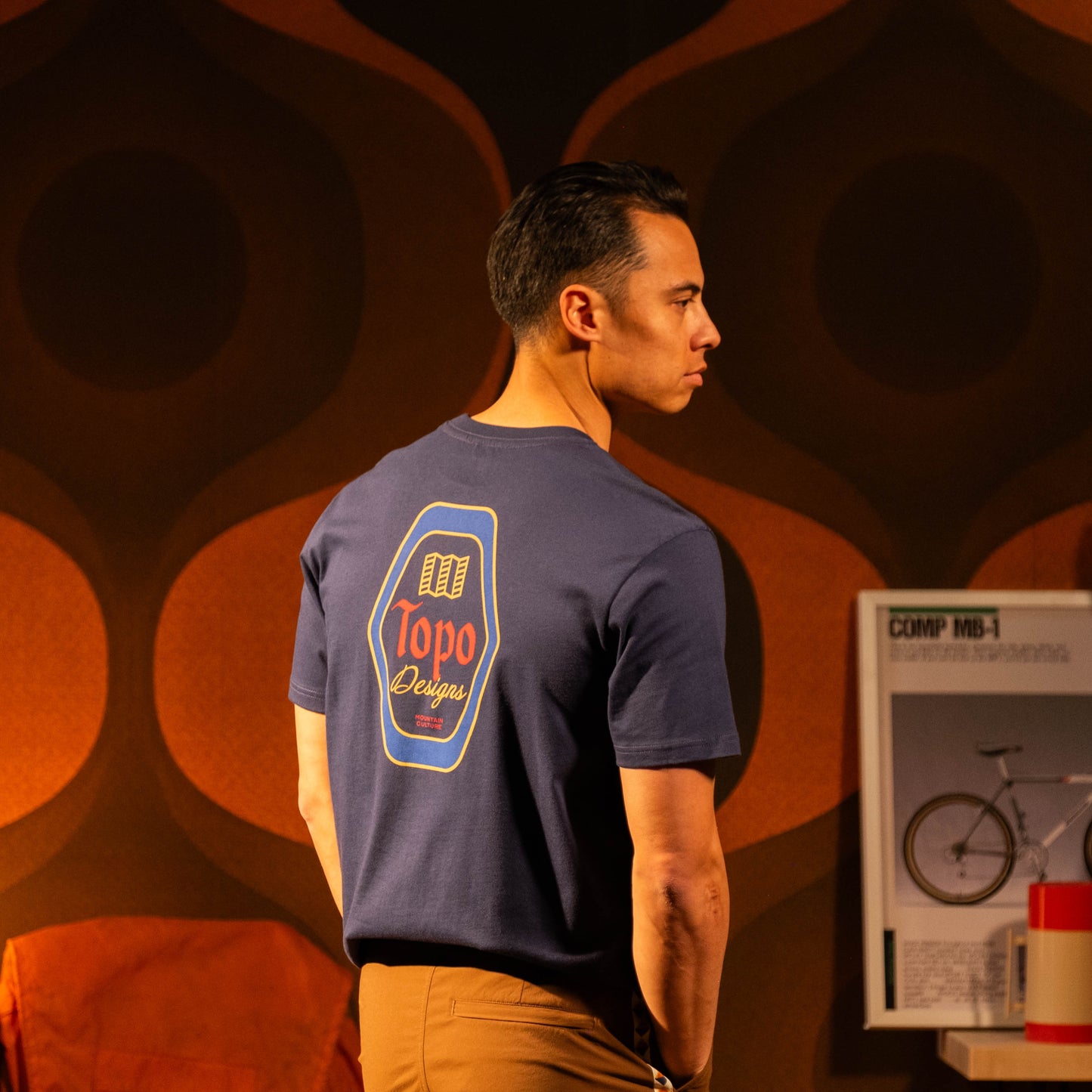 Lifestyle image in studio of male model wearing Topo Designs Draft Tee - Men's in "Midnight"