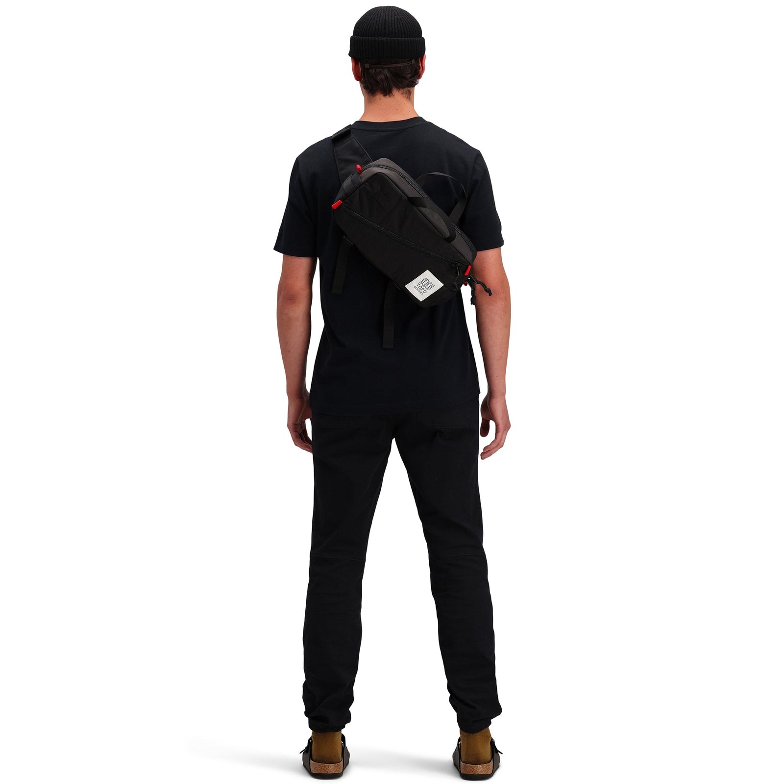 Back model shot of Topo Designs Men's Dirt Pocket Tee 100% organic cotton short sleeve t-shirt in "black". Show on "pond blue"
