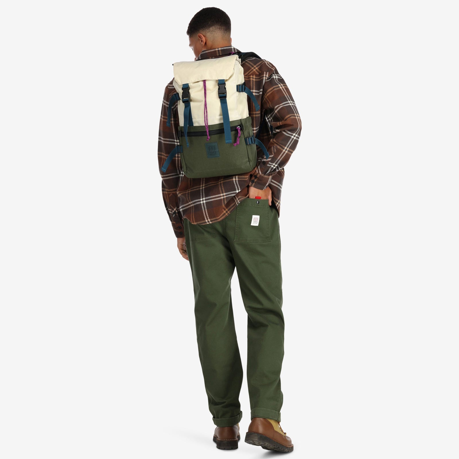 Model wearing Topo Designs Rover Pack Classic laptop backpack in recycled "Bone White / Olive" green.