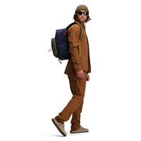 Side model shot of Topo Designs Session Pack laptop backpack in "Olive / Navy"