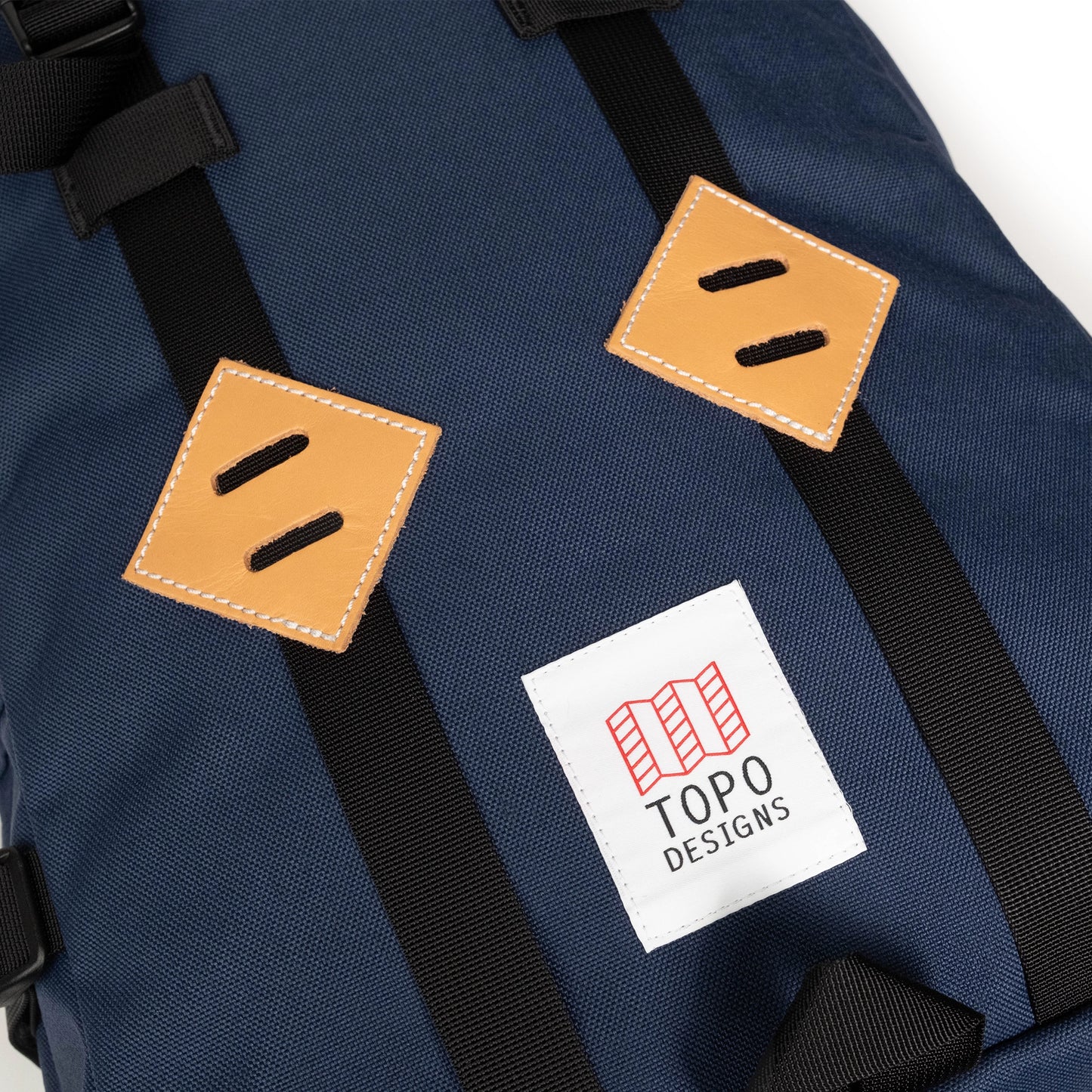 General detail image of leather lash tabs on the front of the Topo Designs Klettersack Classic vintage-inspired rucksack backpack in "Midnight".