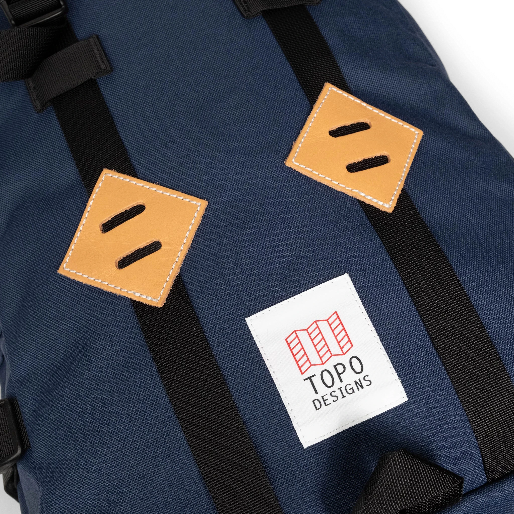 General detail image of leather lash tabs on the front of the Topo Designs Klettersack Classic vintage-inspired rucksack backpack in "Midnight".