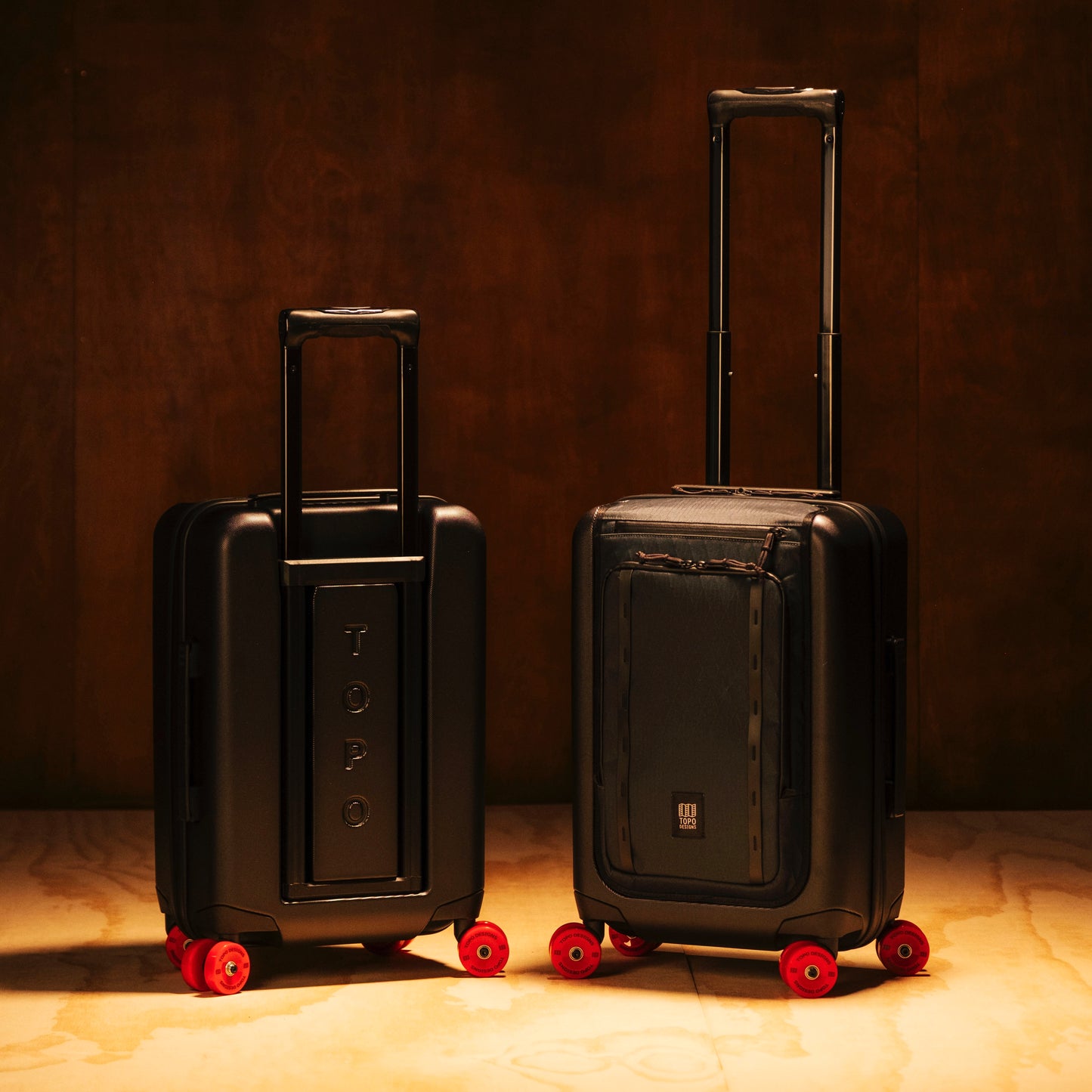 General shot of Topo Designs Global Pro Travel Roller in studio setting showing front and back of bag with handle up