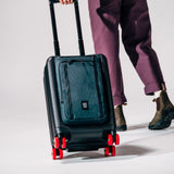 General shot of Topo Designs Global Pro Travel Roller in studio setting with wheels angled and rolling