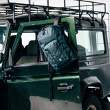 General shot of Topo Designs Global Pro Backpack shown in studio setting on green truck