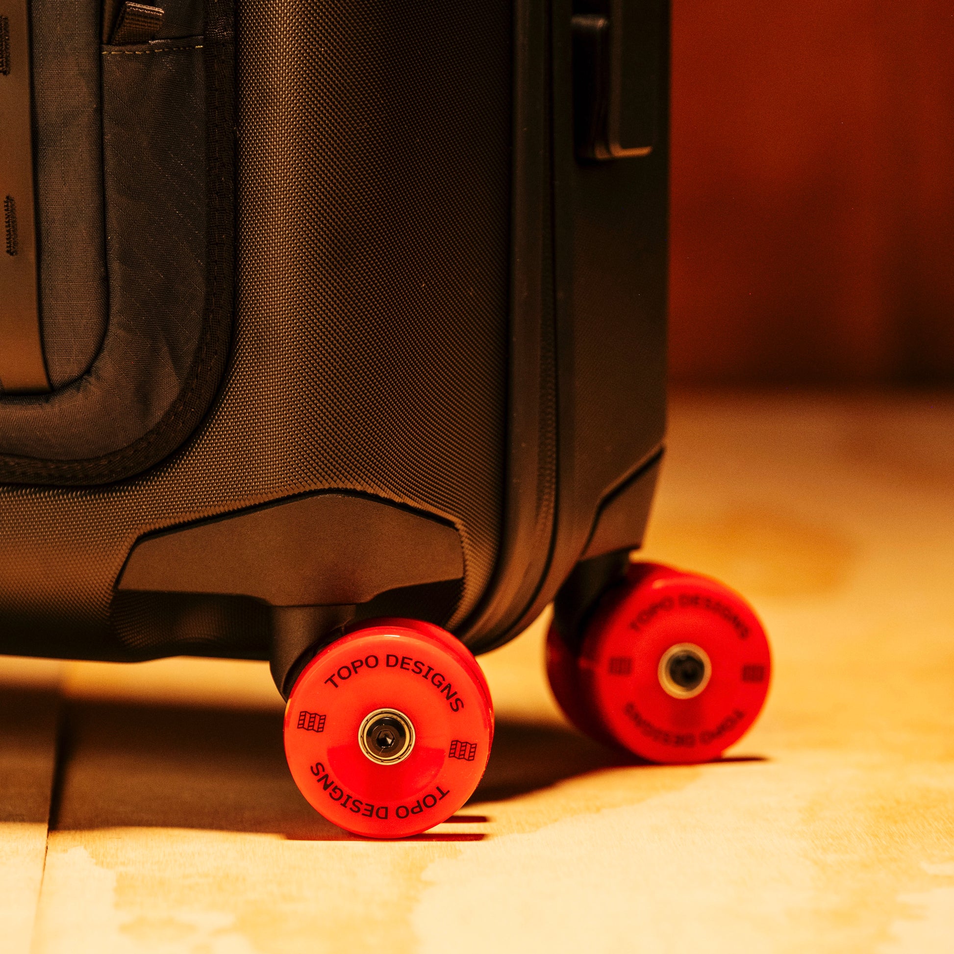 General shot of Topo Designs Global Pro Travel Roller in studio setting showing wheel details