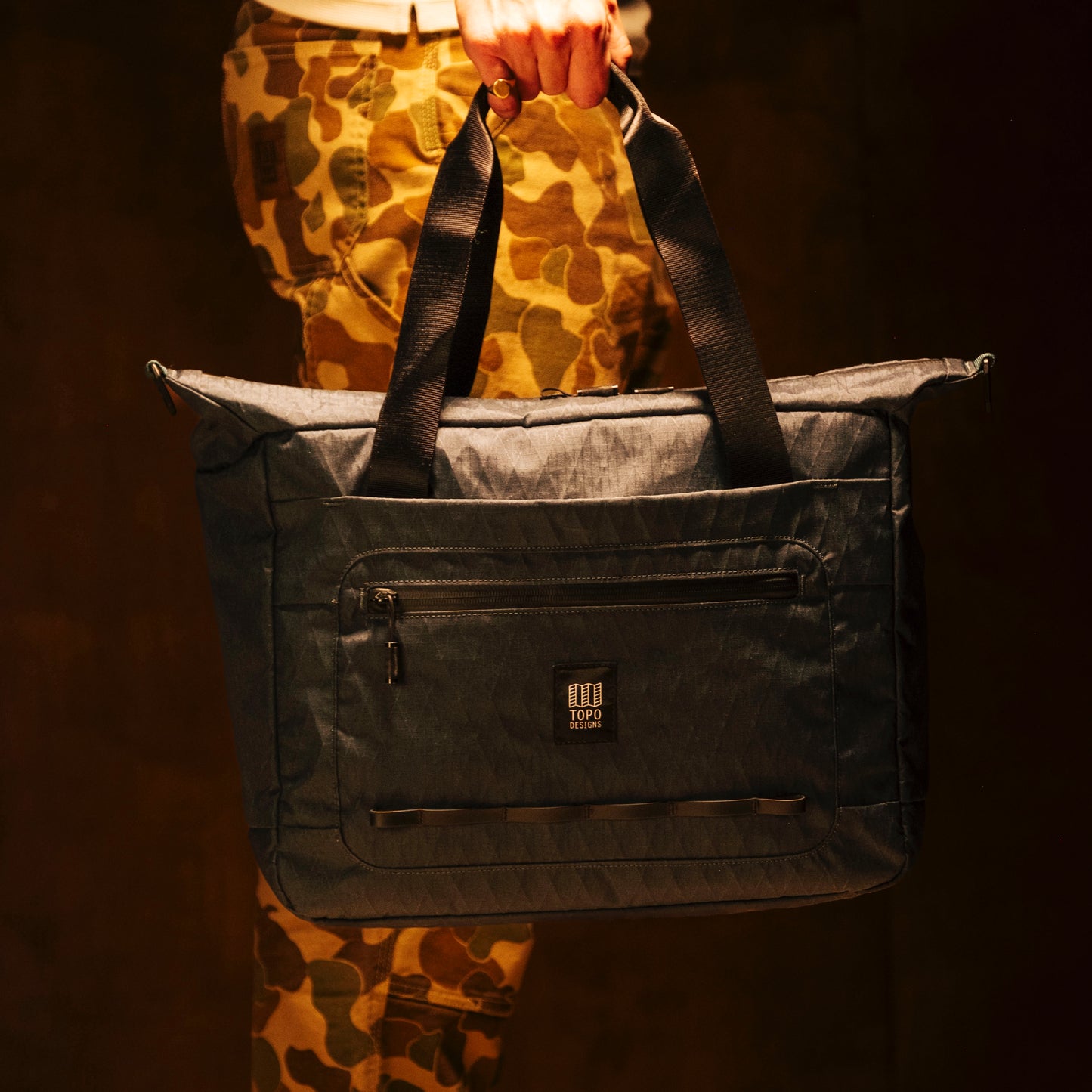 General lifestyle shot of Topo Designs Global Pro Travel Tote showing top handle carry