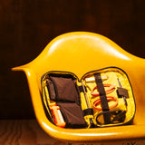 General shot of Topo Designs Tech Case in studio setting shown open with assortment of tech accessories