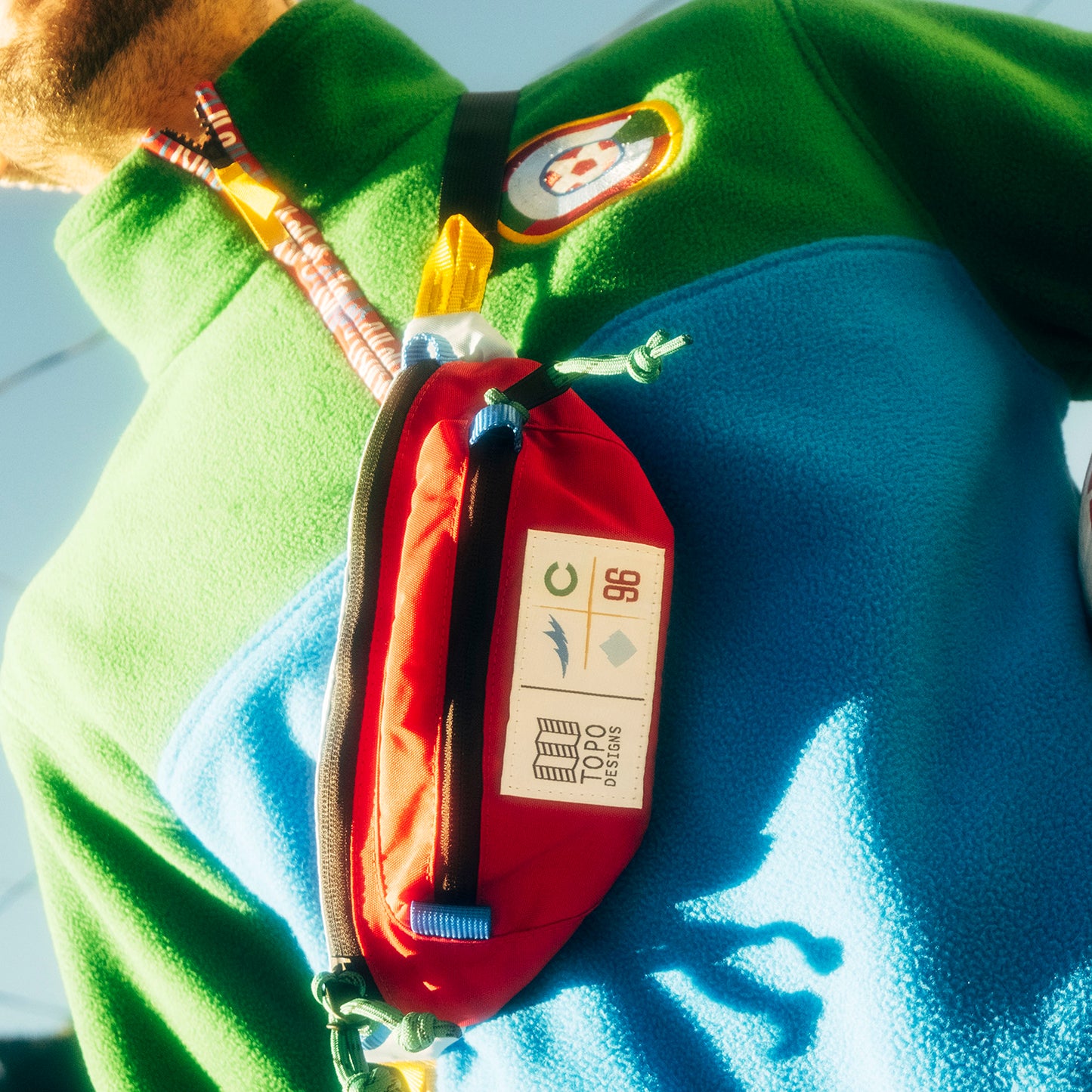 General lifestyle shot of Topo Designs x Colorado Rapids Mountain Waist Pack in "Rio Red / Glacier Blue"