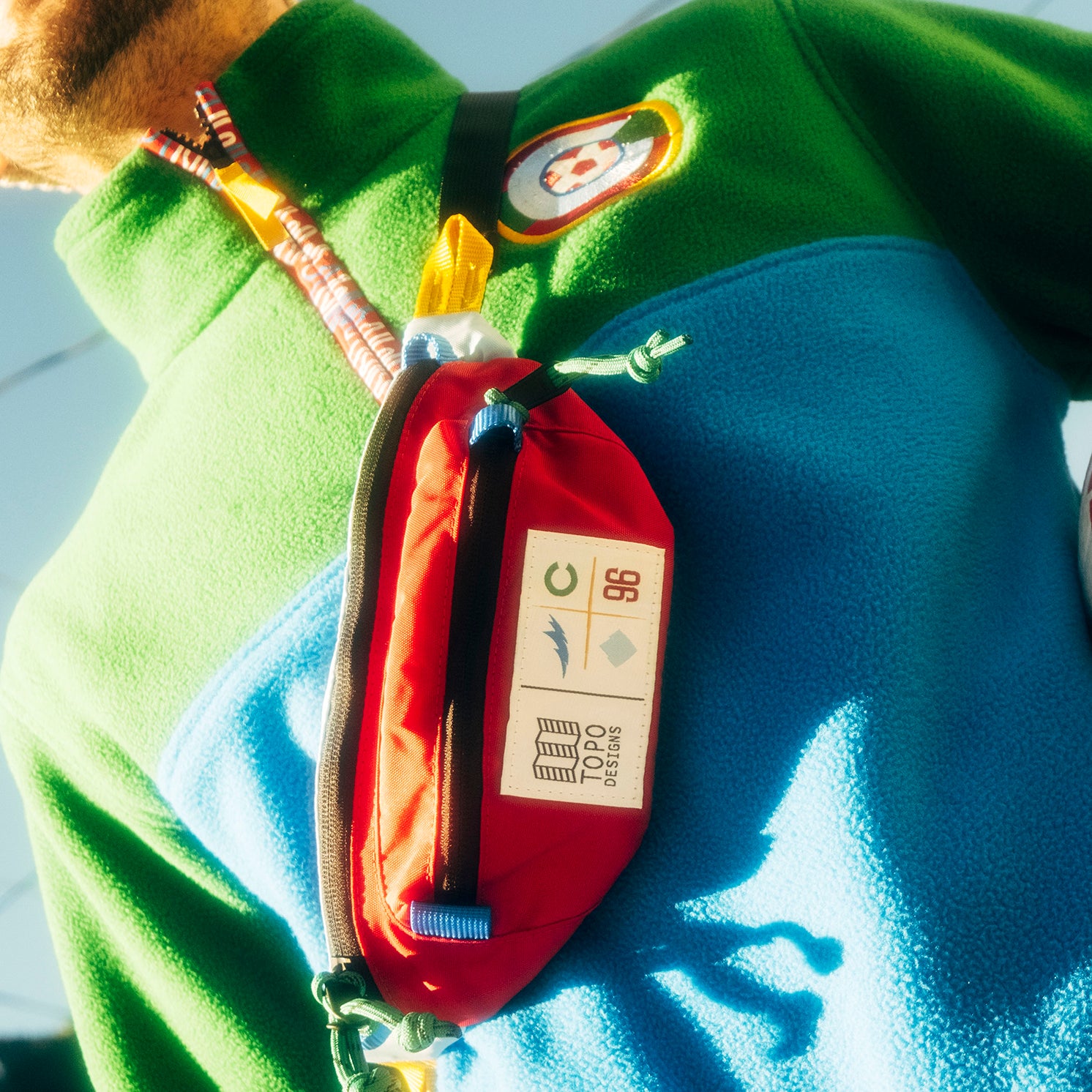General lifestyle shot of Topo Designs x Colorado Rapids Mountain Waist Pack in "Rio Red / Glacier Blue"