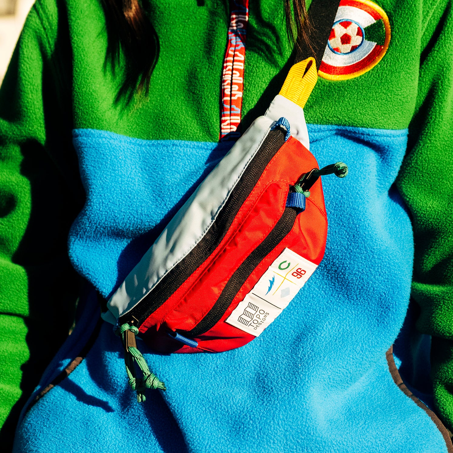General lifestyle shot of Topo Designs x Colorado Rapids Mountain Waist Pack in "Rio Red / Glacier Blue"