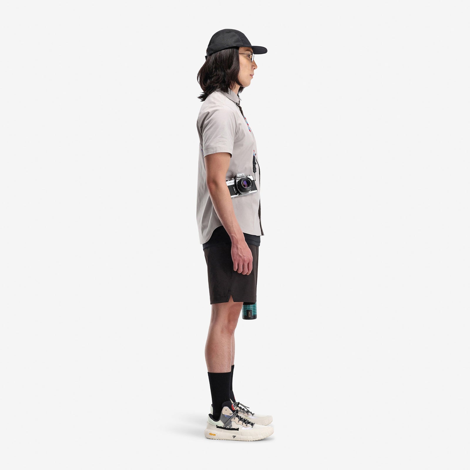 Side model shot of Topo Designs Men's Global lightweight quick dry travel Shorts in "black"