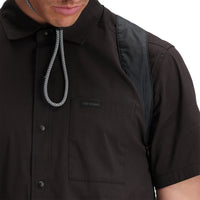 Close up on model, front shot of Topo Designs Men's Global Shirt Short Sleeve 30+ UPF rated travel shirt in "Black".