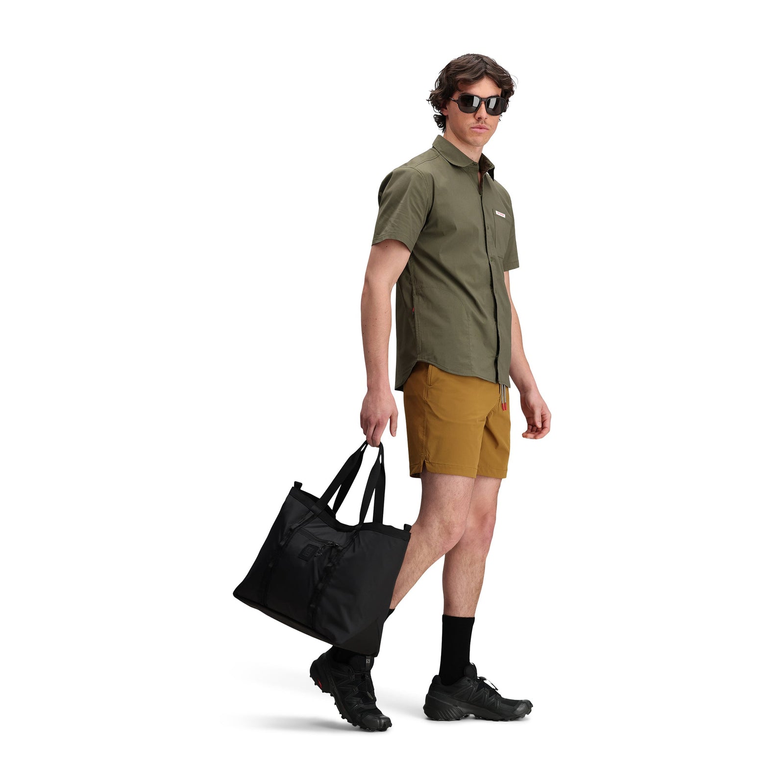 Three quarter model shot of Topo Designs Men's Global Shirt Short Sleeve 30+ UPF rated travel shirt in "Olive" green.