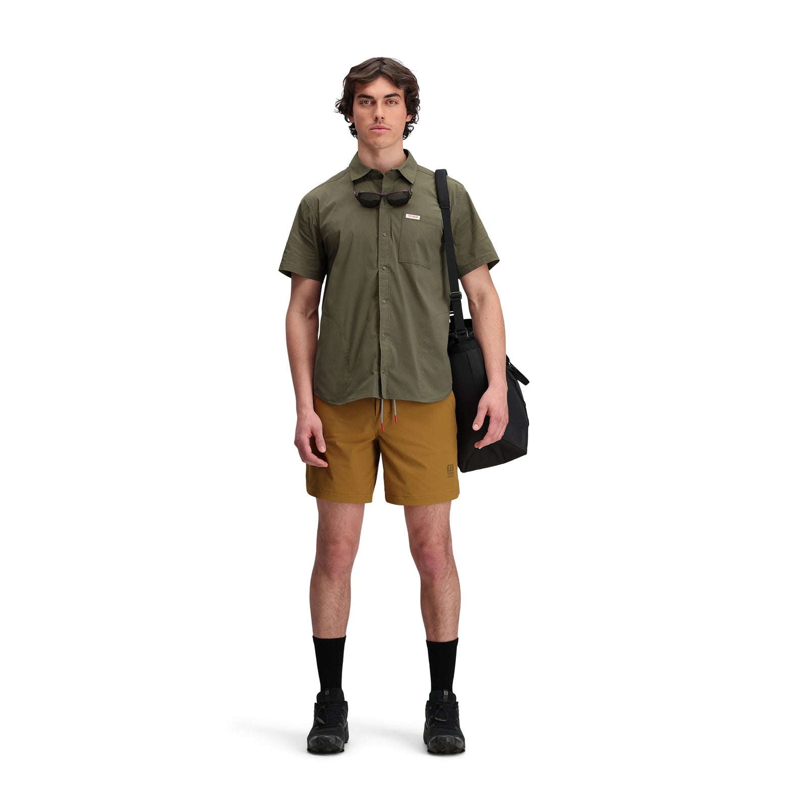 Front model shot of Topo Designs Men's Global Shirt Short Sleeve 30+ UPF rated travel shirt in "Olive" green.