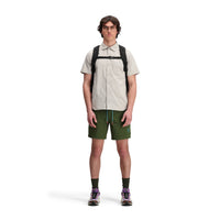 Front model shot of Topo Designs Men's Global Shirt Short Sleeve 30+ UPF rated travel shirt in "Light Gray".