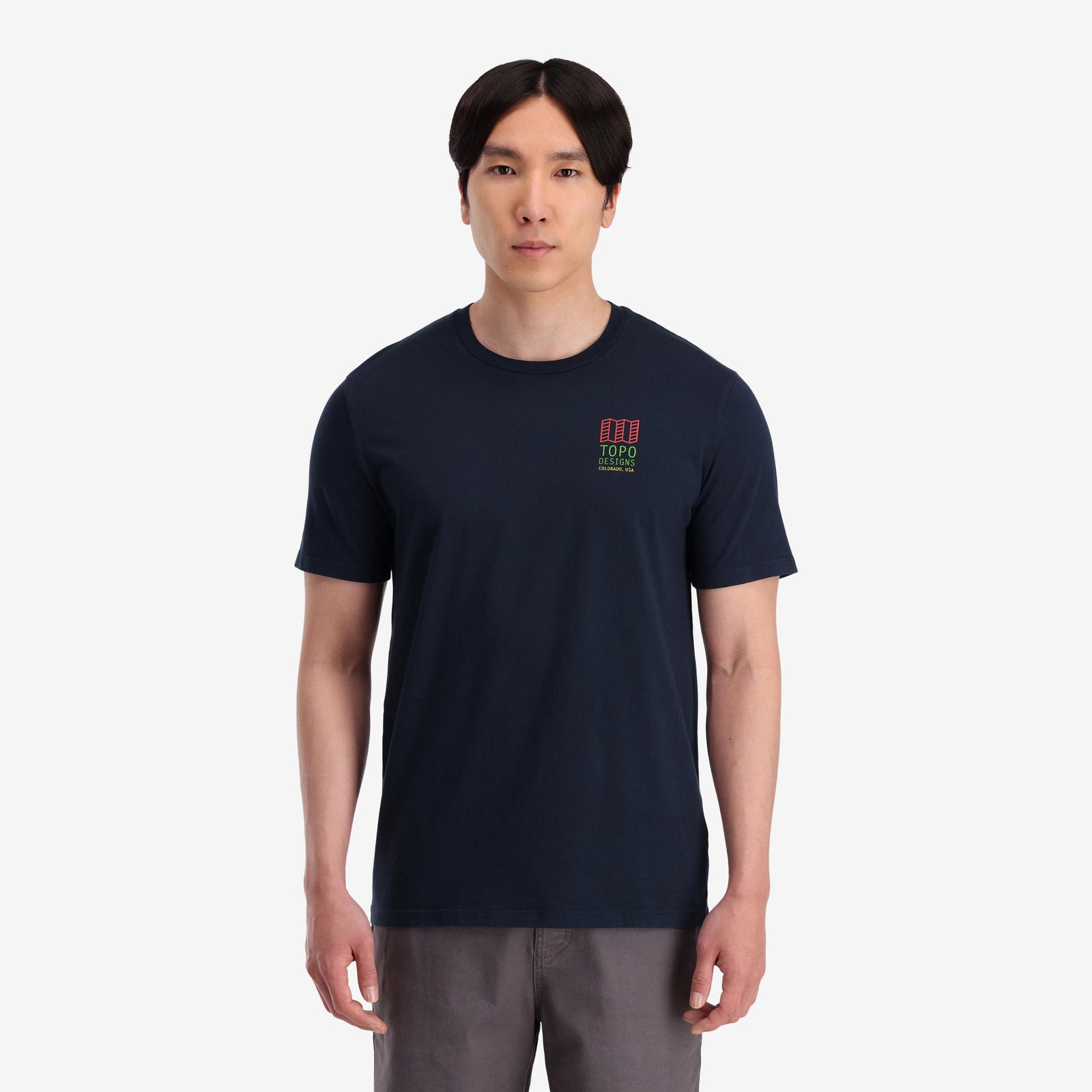 On Model front View of Topo Designs Men's Small Original Logo Tee 100% organic cotton short sleeve graphic logo t-shirt in "navy".
