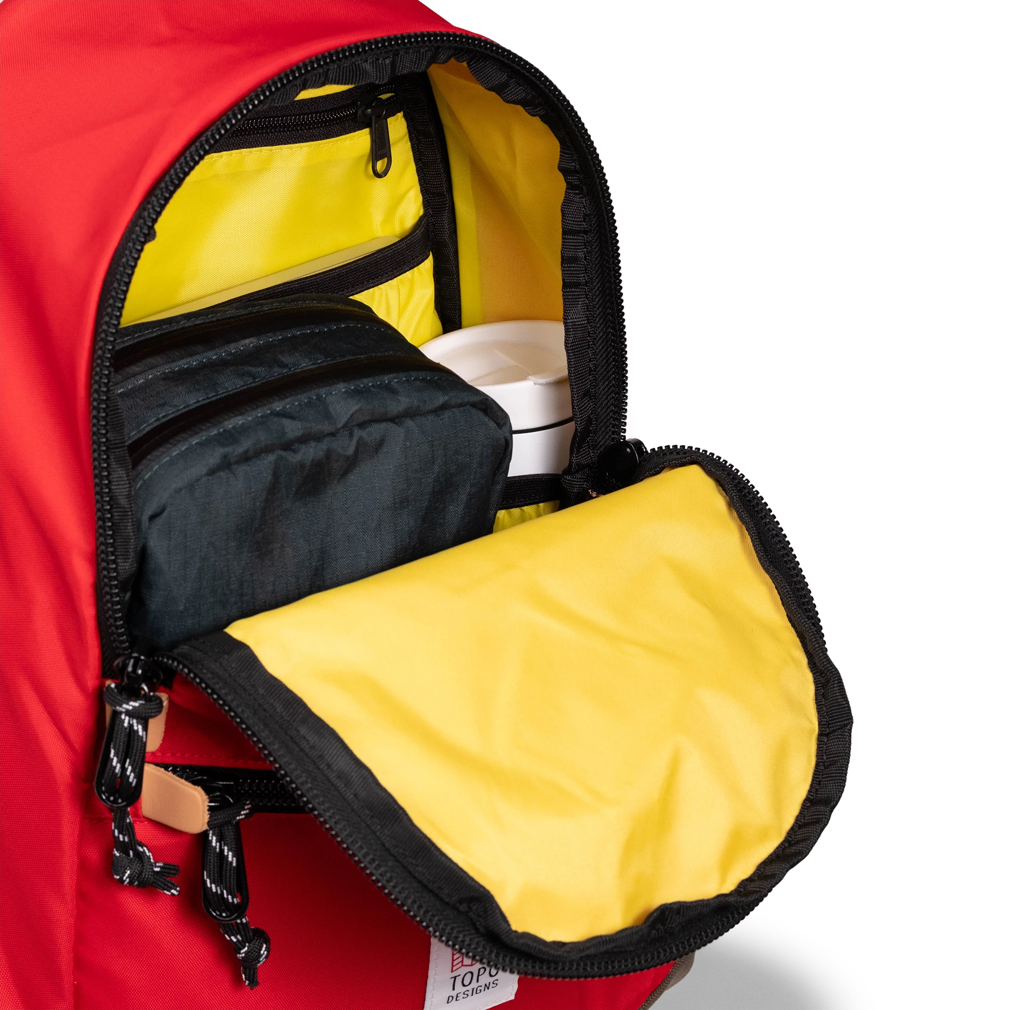 General detail view of Topo Designs Classic Teardrop Backpack in "Salsa" with the main compartment opened.