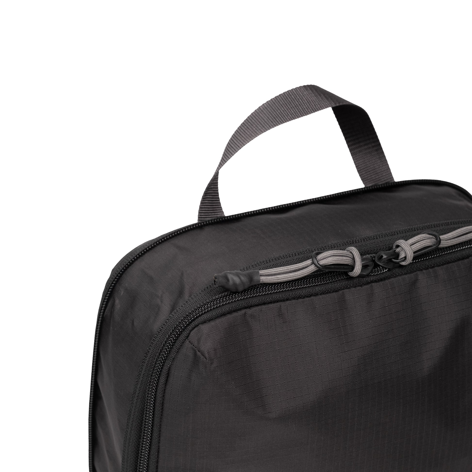Top zipper detail white background image of Topo Designs Global Compression Pack Bag Set in "Black / Black"
