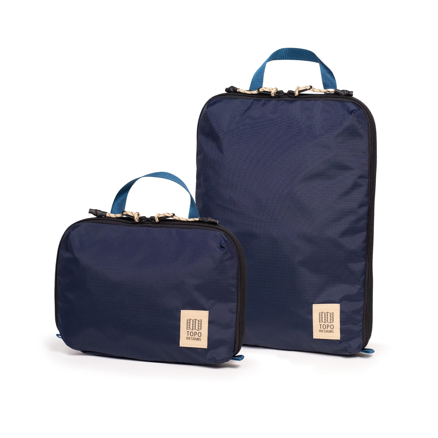 Front quarter white background image of Topo Designs Global Compression Pack Bag Set in "Navy / Sahara"