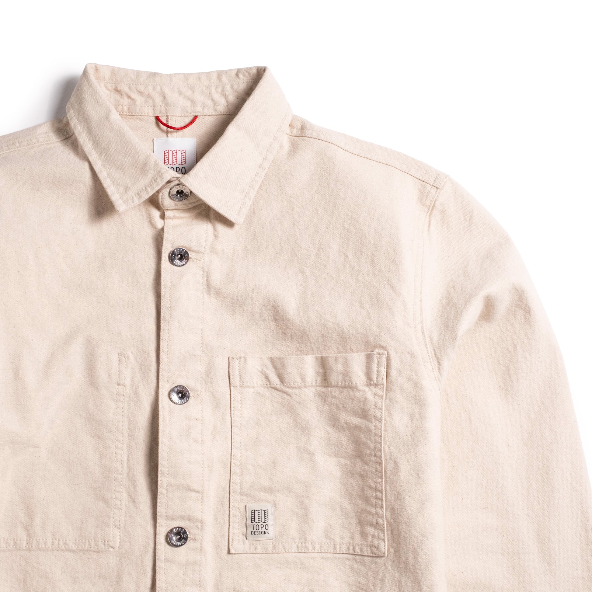 Front detail collar and pocket view of Topo Designs Utility Jacket Undyed - Men's in "Undyed"