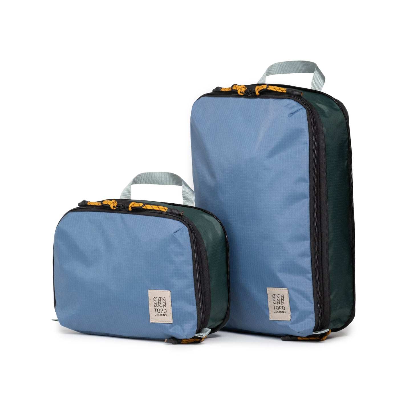 Front quarter white background image of Topo Designs Global Compression Pack Bag Set in "Stone Blue / Forest"