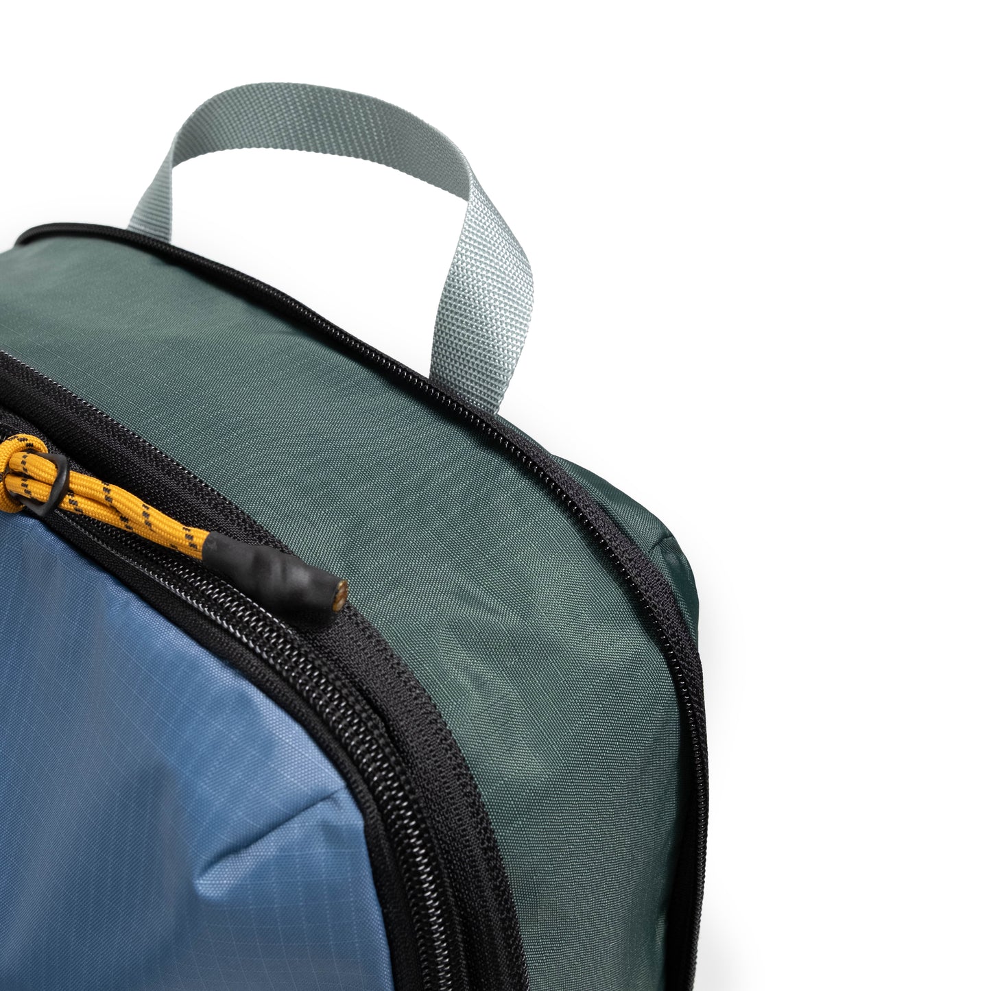 Front zipper detail white background image of Topo Designs Global Compression Pack Bag Set in "Stone Blue / Forest"