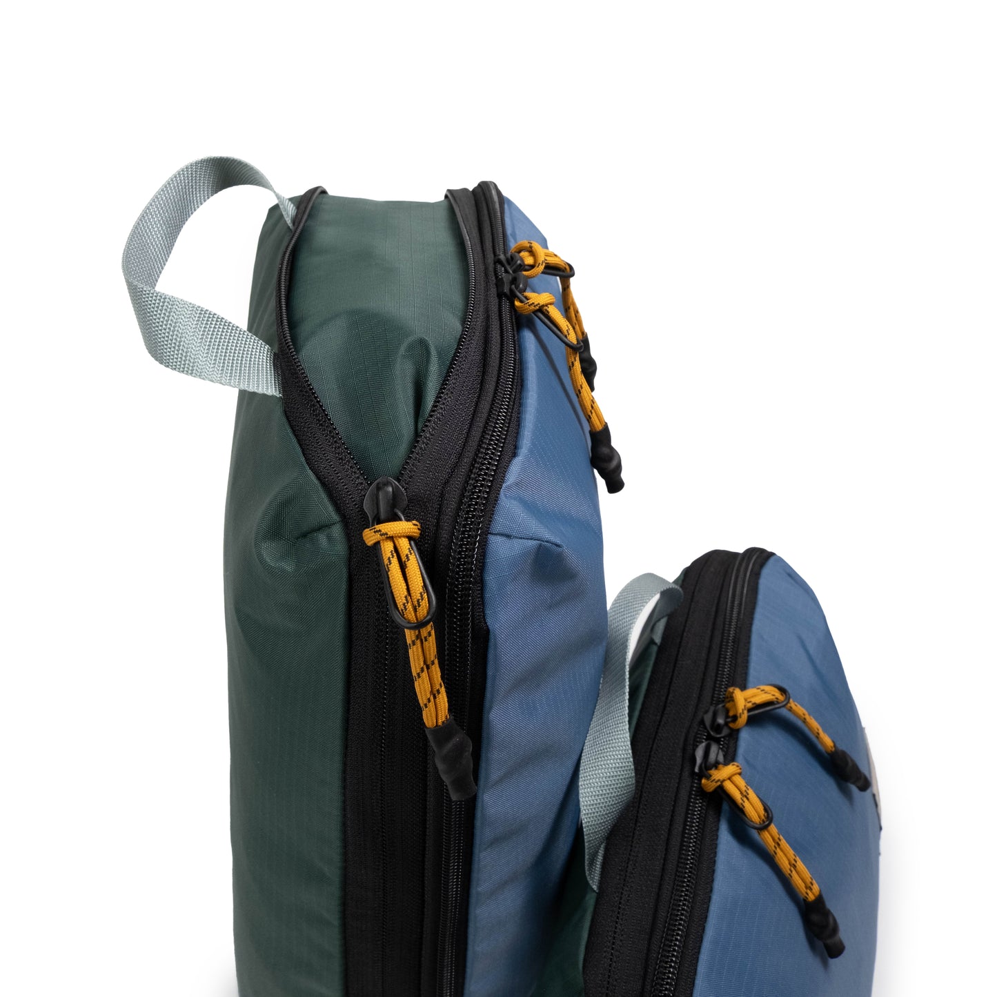 Side zipper detail white background image of Topo Designs Global Compression Pack Bag Set in "Stone Blue / Forest"