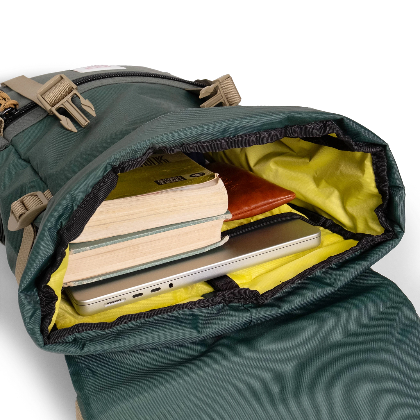 General shot Topo Designs Rover Pack Classic laptop backpack in "Forest" showing interior shot of backpack packed out with laptop, books, and glasses case.