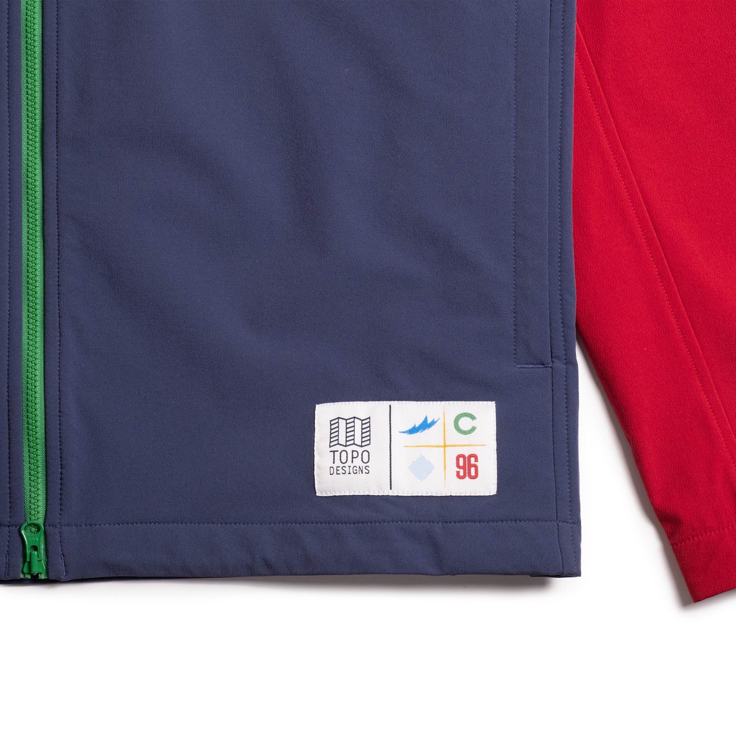 Front bottom detail view of Topo Designs x Colorado Rapids HighPeak Jacket in "Rio Red / Midnight"