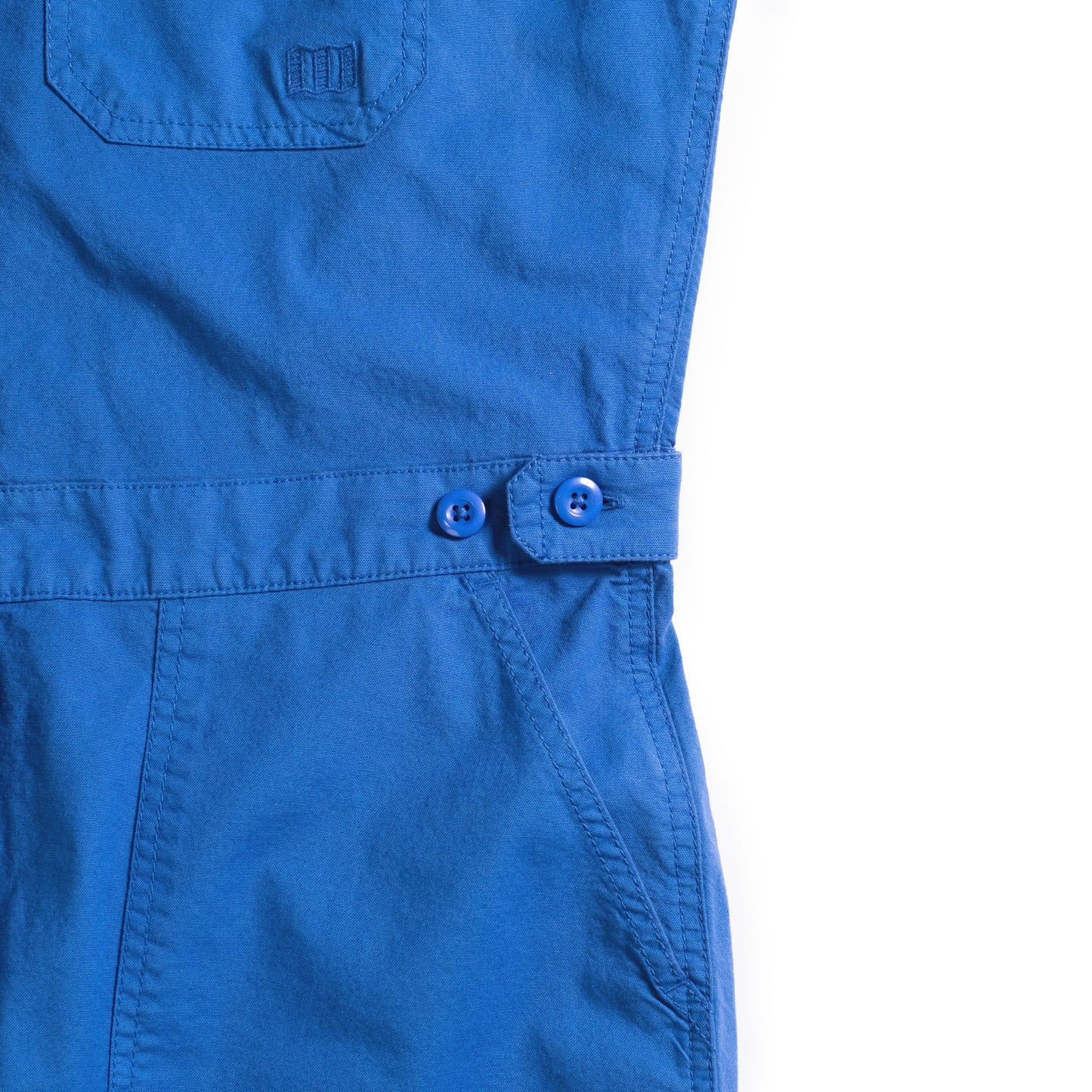 Front pocket detail white background flat lay image of Topo Designs Desert Coverall - Women's in "French Blue"