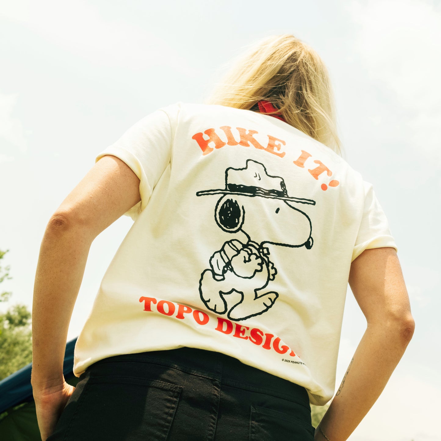 Person wearing a white t-shirt with Snoopy and Woodstock graphic and 'Hike It!' text on the back.