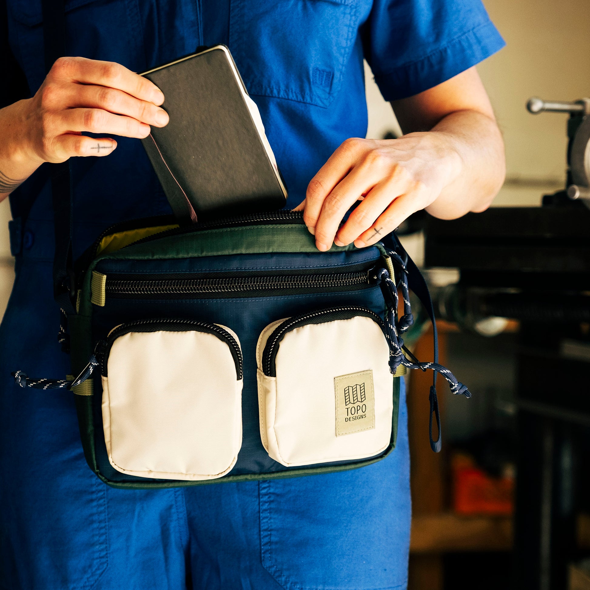 General lifestyle photo of model with Topo Designs Block Bag in "Forest / Bone White"