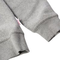 General detail of men's global sweater in gray showing wide-ribbed sleeve hem.