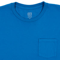 General detail product shot of Topo Designs Men's Pocket Tee Long Sleeve in blue showing the neck hem and chest pocket.
