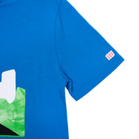 General detail shot of the Men's Short Sleeve Sun Tee in blue showing Topo Designs logo on sleeve.