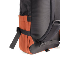 General 3/4 back detail shot of the Topo Designs Rover Pack Classic in Black/Clay showing collapsible water bottle pockets on side