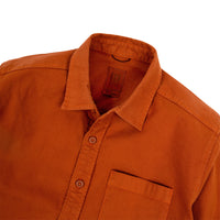 General detail shot of Topo Designs Men's Dirt Shirt in Brick orange showing collar, inside tag, buttons, and chest pocket.