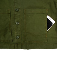 General detail shot of Topo Designs Women's Dirt Jacket in Olive green showing iPhone in front hand pocket.