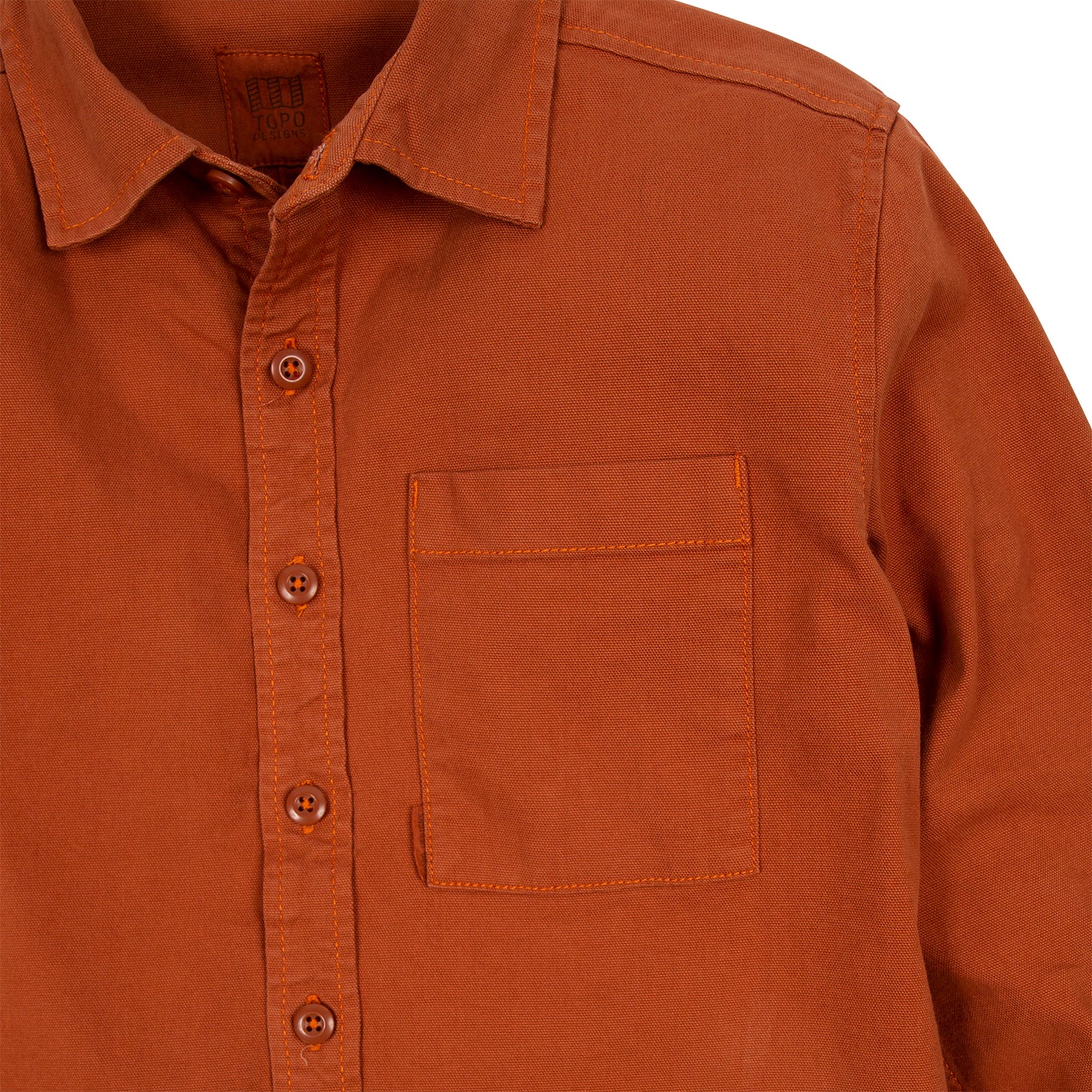 General detail shot of Topo Designs Women's Dirt Shirt in Brick orange showing front buttons and chest pocket.