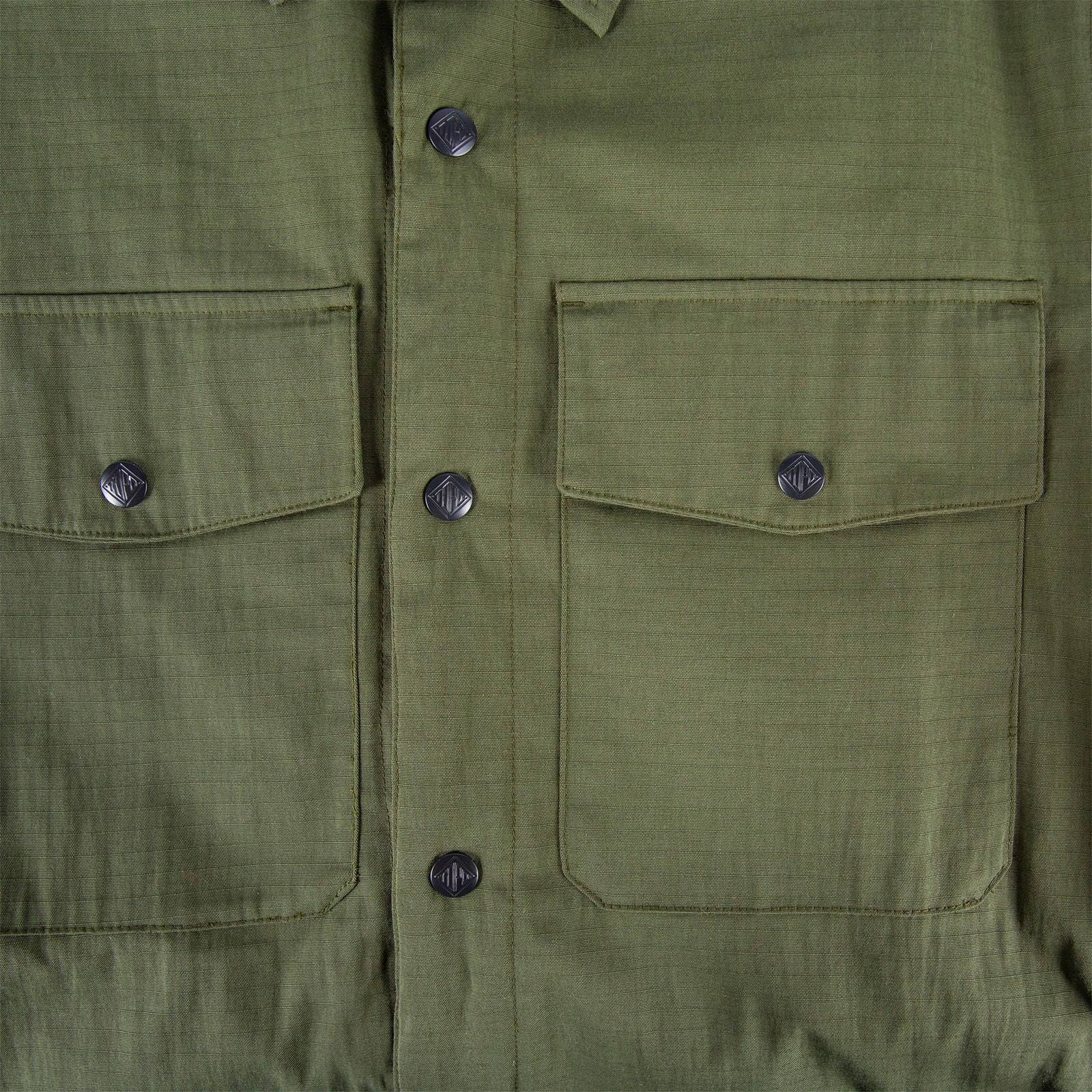 General front detail shot of Men's Topo Designs Insulated Shirt Jacket in Olive green showing chest pockets and buttons.