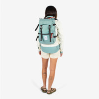 Topo Designs Rover Pack Classic in "Sage" green on model carried with backpack straps.