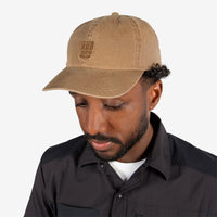 General front model shot of Topo Designs Mountain Ball Cap cotton logo hat in "Dark Khaki" brown