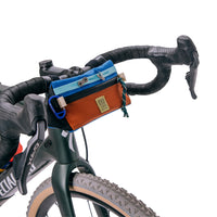 Topo Designs Bike Bag Mini Mountain bicycle handlebar bag in "clay / blue" lightweight recycled nylon on bike.