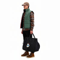Side model shot of Topo Designs Men's Mountain Puffer recycled insulated Vest in "Forest" green.